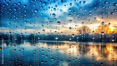 A Serene Water Reflection Viewed Through Raindrops on Glass During a Colorful Dawn