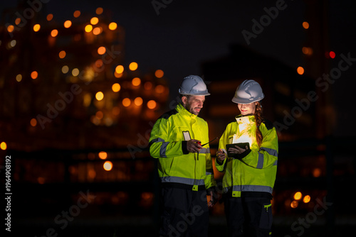 Billede på lærred Engineers working night shift at industrial plant with tablet