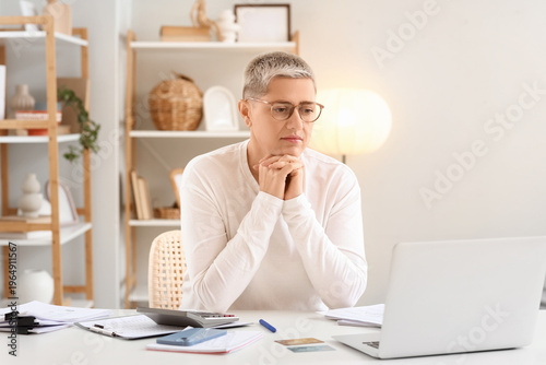 Sad mature woman in debt si...