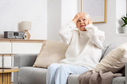 Senior woman on sofa suffer...