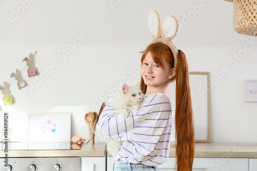Photos Cute girl with adorable cat and bunny ears in festive kitchen