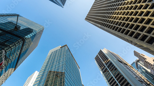 Low angle view of modern skyscrapers against clear blue sky in financial district, showcasing urban architecture, business growth, corporate environment and future city development concept