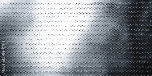 A closeup of a dark gray brushed metal plate texture with a silver metallic steel surface design creates a grunge wallpaper backdrop
