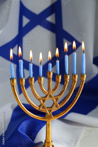 Foto Hanukkah menorah with lit blue candles in front of Israeli flag, Jewish holiday