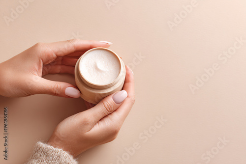 Clean and organic aesthetic of a skincare routine featuring cream texture on a beige background with soft lighting and copy space.