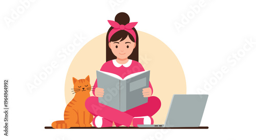 Young girl in pink loungewear sitting cross-legged reading a large book while a tabby cat and a laptop keep her company at home.