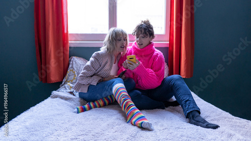 Lesbian couple using smartphone showing rainbow pride socks