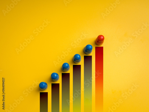 Quadro su tela Blue human figures on rising bar chart with red leader on top, symbolizing leadership, population growth, progress, human development, social dynamics, and team management on yellow background