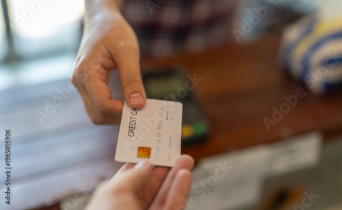 Картината върху платно Close up of customer hand giving white credit card to cashier at retail store co