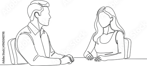 Man and woman in formal attire sitting at table, having serious conversation.