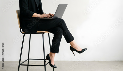 Woman sitting relaxed while using laptop on high chair