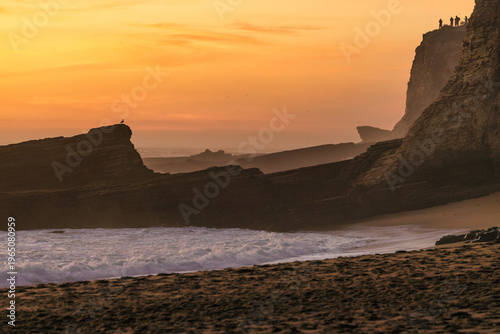 Golden sunset over rugged coastal cliffs with layered rock formations, gentle ocean waves and warm evening light, creating a peaceful and cinematic seascape with dramatic shoreline 