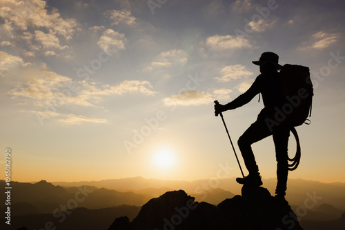 Silhouette of a Climber at the top of the rocky mountain at sunset, Man on top of mountain. Conceptual design. alone at the summit climber  successful climbers. Sport and active life.