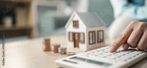 Mortgage calculation with house model and calculator, representing home loan planning, interest rates, monthly payments, and real estate financing.