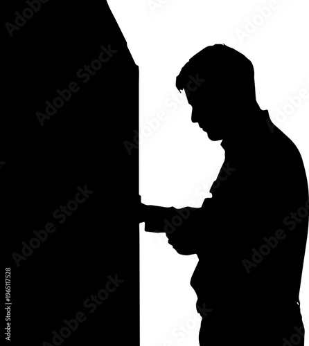 Silhouette of a Man Using an Automated Teller Machine ATM for Cash Withdrawal or Banking Transactions