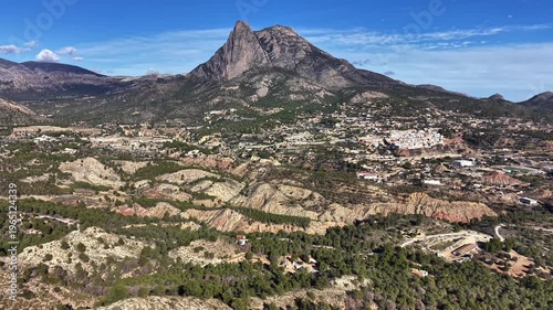 aerial mountain landscape with rugged peak hiker viewpoint overlooking sunlit valley, terraced slopes,