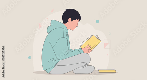 Young man sitting cross legged reading a book indoors with casual clothes and relaxed posture