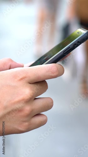 Closeup of female hand hold and touch screen smartphone at Seville street background. Asian woman using cell phone in Spain. Girl messaging on smart-phone. People travelers using device mobile