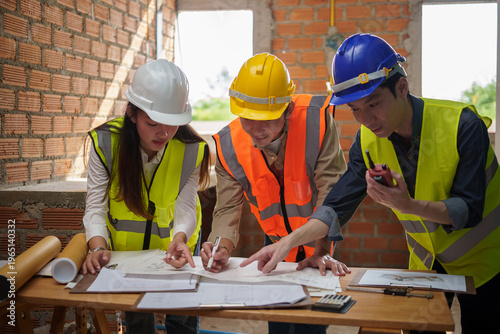 Construction workers reviewing blueprints and coordinating work for a building development project.