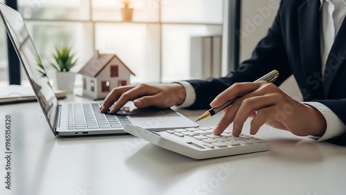 Professional hands manage laptop and calculator for financial planning.