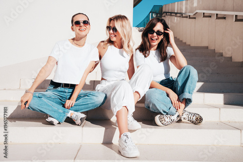 Foto Three young beautiful smiling hipster female in trendy summer t-shirt  and jeans clothes
