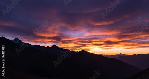 Breathtaking sunset over mountainous landscape with vibrant colors reflecting on clouds