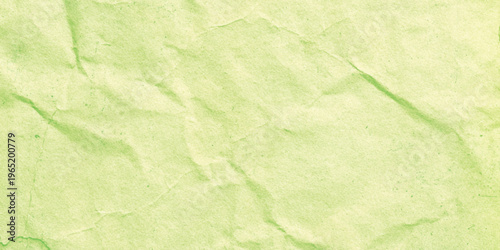 Crumpled green paper texture background with creases and wrinkles for design