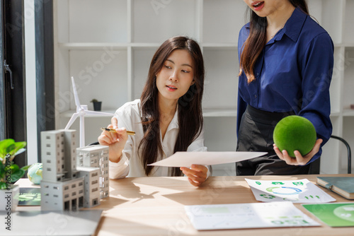 Businesswomen discussing sustainable green architecture and renewable energy