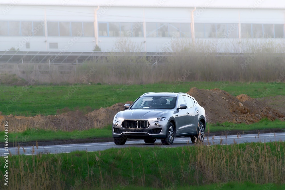 Fototapeta premium Luxury SUV car passing construction site
