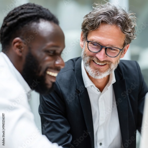 professionals wearing collaborate and talk at a modern office, showing teamwork, communication, and a positive work environment.