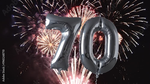 Silver balloon number 70 with fireworks in the background. Festive scene for birthday or anniversary party