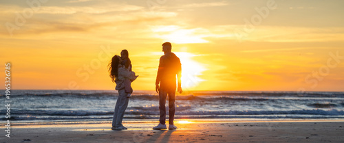 Family enjoying beach sunset together during vacation