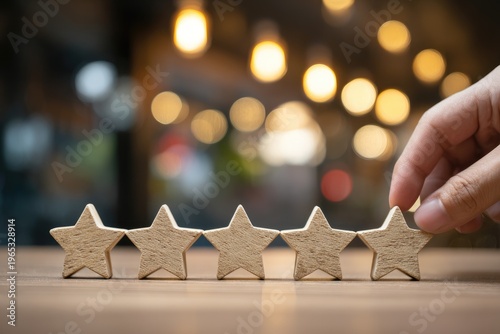 Hand places last wooden star. Five-star rating concept with soft focus lights