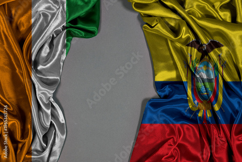 Silk Flags Of Ivory Coast And Ecuador Draped On Gray Background For International Concept