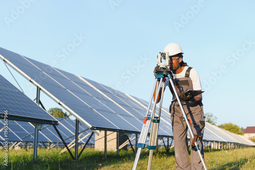 Billede på lærred Engineer surveying solar farm for renewable energy project