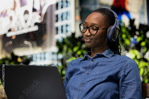 Φωτογραφία Relaxed person on park bench uses laptop to watch movies, smiling