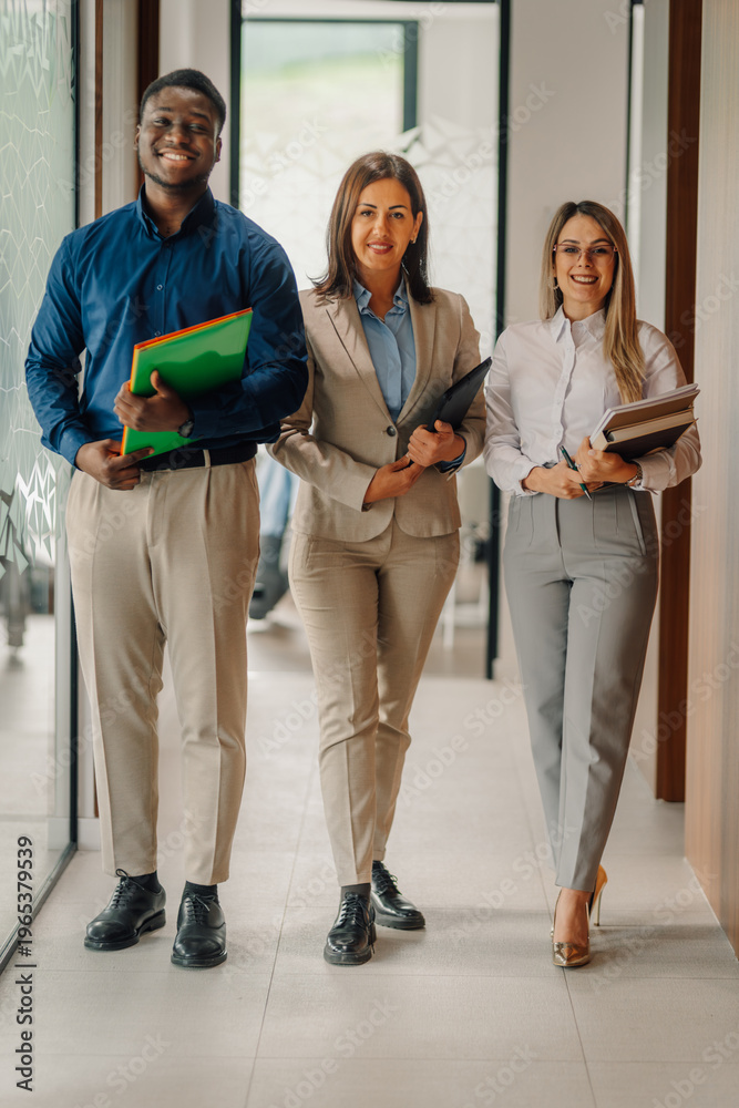 Fototapeta premium Diverse business team walking through office corridor