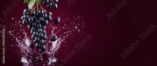 Falling grapes with juice splash and droplets on rich burgundy background with copy space