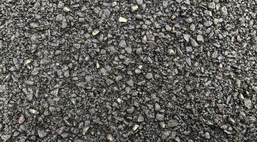 Close up of new black asphalt texture background with small stones and grainy surface