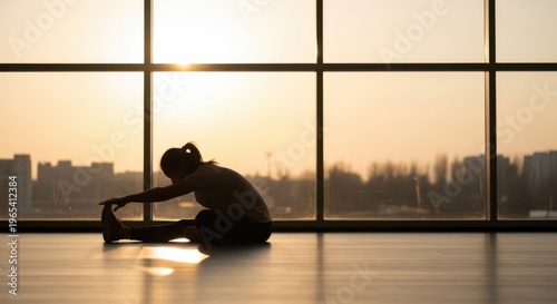 Woman stretching in front of a large window at sunset