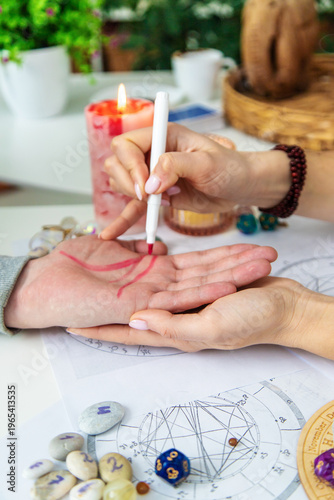 Bilde på lerret Astrologer drawing zodiac symbols on client's palm during esoteric reading sessi