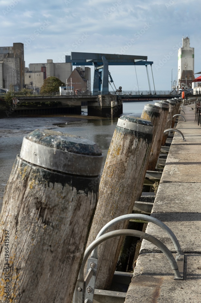 Fototapeta premium Husum is a picturesque town located in Schleswig-Holstein, Germany, known for its maritime heritage, charming architecture, and scenic surroundings. Harbor at low tide.