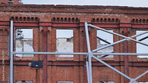 Fotografía Urban brick building facade undergoing restoration with steel support structure