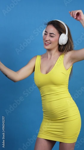 Young woman in yellow dress dancing and taking a selfie