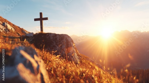 Sunset over mountains with cross on hilltop in the background