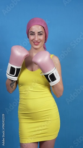 Determined woman with cancer fighting with pink boxing gloves