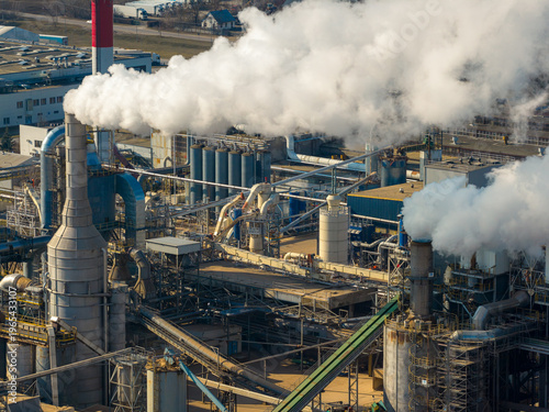 Aerial view of industrial complex manufacturing wood products, consuming raw materials while emitting steam and smoke, Grajewo, Podlaskie Voivodeship, Poland.
