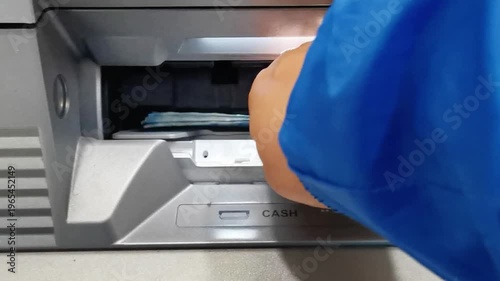 Person withdrawing 50000 denomination banknotes from ATM machine