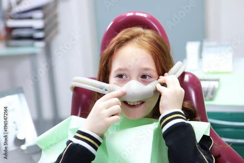 Little girl with sedation mask. Treatment of children's teeth with nitrous oxide. Children's dentistry. Anesthesia for children in dental treatment.