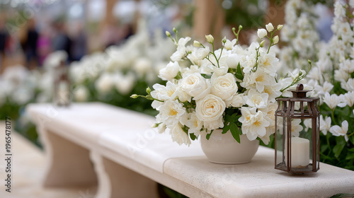 Elegant white flower arrangement with lantern on stone bench in garden setting